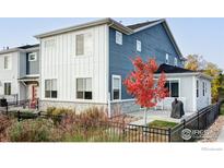 Two-story home with blue and white siding, a stone foundation, and manicured landscaping at 784 Stonebridge Dr, Longmont, CO 80503