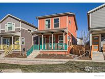 Charming two-story home with a vibrant orange facade and inviting front porch at 10331 E 62Nd Pl, Denver, CO 80238