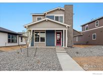 Charming two-story home featuring a brick chimney, colorful door, and a well-maintained yard at 2267 Peregrine Dr, Brighton, CO 80601
