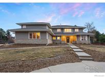 Beautiful two-story home with manicured lawn and stone accents provides a warm and inviting appeal at 2527 Columbine Cir, Lafayette, CO 80026