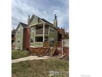 View of home exterior, with second story balcony, a chimney, and a grassy yard at 3025 Broadway St # 17, Boulder, CO 80304