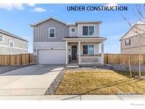 Under construction, a charming two-story home boasts a welcoming porch, a two car garage and landscaped yard at 4206 Sandstone Dr, Mead, CO 80504