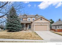 Charming two-story home with a stone and siding exterior, complemented by a well-maintained front yard and a two-car garage at 4463 Eagle River Run, Broomfield, CO 80023