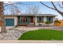 Charming home with a manicured lawn and inviting front porch, showcasing great curb appeal and a blue accent color at 1700 Jewel Dr, Longmont, CO 80501