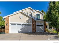 Charming two-story home featuring a three-car garage, light siding, and a well-maintained front yard at 2215 Barn Swallow Dr, Longmont, CO 80504