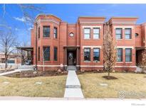 Stunning brick townhome featuring a well-manicured front yard and inviting entryway at 2890 Curtis St, Denver, CO 80205