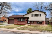 Charming red brick and vinyl home with attached garage and front yard featuring beautiful green lawn at 3690 Conifer Ct, Boulder, CO 80304