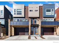 Modern townhome with stone accents, garage, and multiple windows, creating an inviting curb appeal at 737 Kubat Ln # B, Longmont, CO 80503