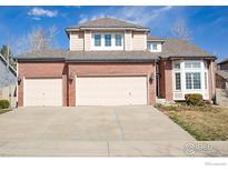 Charming red brick two-story home with an attached three-car garage and large concrete driveway at 1069 Monarch Way, Superior, CO 80027
