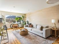 Inviting living room featuring a comfortable sofa, textured rug, and large windows with mountain views at 1201 Balsam Ave # 302, Boulder, CO 80304