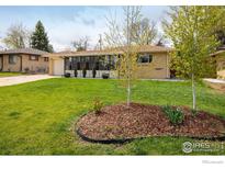 Charming ranch-style home featuring a well-manicured lawn, mature trees, and ample natural light at 169 Emerald St, Broomfield, CO 80020