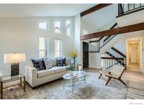 Bright living room with large windows, stylish decor, and a staircase with wooden beams at 2650 Hawthorne Pl, Boulder, CO 80304