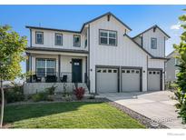 Charming two-story home with a three-car garage, covered front porch and a well-manicured lawn at 299 Bronco Ct, Berthoud, CO 80513