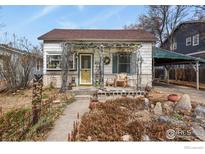 Charming single-story home featuring a cozy porch, landscaped garden, and detached carport at 305 E Cannon St, Lafayette, CO 80026