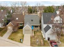 Charming home featuring a blue front door, attached garage, and well-maintained lawn at 4866 Brandon Creek Dr, Boulder, CO 80301