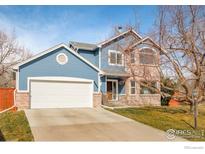 Charming two-story blue home with a two-car garage, brick accents, and a well-maintained front yard at 6825 Bugle Ct, Boulder, CO 80301