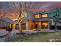 Charming two-story home featuring a three-car garage, inviting front porch, and landscaped front yard at sunset at 823 W 126Th Pl, Westminster, CO 80234