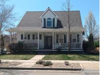 Charming two-story home with a welcoming front porch and well-manicured lawn at 1228 Allen Ave, Erie, CO 80516