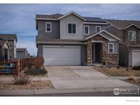 Charming two-story home boasts a stone-accented entryway and a spacious two-car garage at 15325 W 93Rd Ave, Arvada, CO 80007