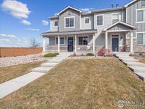 Inviting two-story home with a charming front porch and landscaped front yard at 16611 E 119Th Ave # E, Commerce City, CO 80022