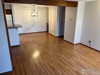 Open-concept living and dining area with wood-look flooring and modern lighting fixture at 2992 Shadow Creek Dr # 203, Boulder, CO 80303