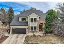 Charming two-story home features a stone archway entrance, modern garage door, and landscaped front yard at 325 Peregrine Cir, Broomfield, CO 80020