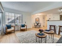 Bright living room featuring hardwood floors, large windows, and cozy decor at 4799 White Rock Cir # D, Boulder, CO 80301