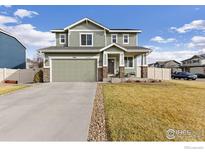 Charming two-story home with a well-maintained front yard and attached two-car garage at 5941 Oak Meadows Blvd, Firestone, CO 80504