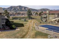Scenic community view featuring a covered pool, lush lawns and distant mountain views at 695 Manhattan Dr # 213, Boulder, CO 80303