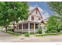 Charming home featuring a covered porch, lush landscaping, and beautiful architectural details at 906 Confidence Dr, Longmont, CO 80504