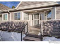 Inviting front entrance with stairs, railing, and storm door plus plenty of natural light from windows and covered patio at 6826 W 84Th Cir # 14, Arvada, CO 80003