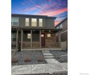 Charming home featuring a covered front porch and stone facade for added curb appeal at 7017 Kali Ct, Frederick, CO 80530