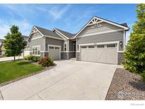 Charming home featuring a well-manicured front yard, stone accents, and an attached two-car garage at 892 Sundown Way, Erie, CO 80516