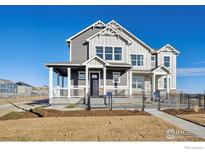 Charming two-story home showcasing a covered front porch and black iron fencing at 924 Andrews Crest Dr, Berthoud, CO 80513