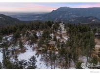 Breathtaking aerial view of a mountain home nestled among the trees with stunning mountain views at 93 Hawk Ln, Boulder, CO 80304