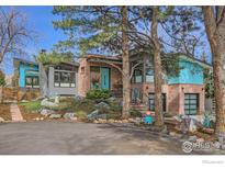 Striking modern home with brick and gray exterior, beautiful front yard landscaping, and a bright turquoise door at 955 Jasmine Cir, Boulder, CO 80304
