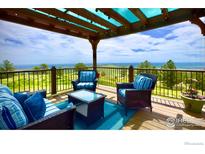 Inviting covered deck with comfortable seating and stunning views of the surrounding landscape at 15757 Mossrock Ct, Longmont, CO 80503