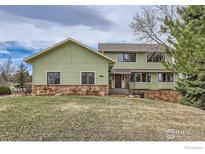 Charming home featuring stone accents, a well-manicured lawn, and a welcoming entrance at 4057 Niblick Dr, Longmont, CO 80503