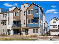 Exterior shot showcasing a modern townhome with a balcony and a mix of brick and siding, in a vibrant neighborhood at 12296 W 56Th Ln, Arvada, CO 80002
