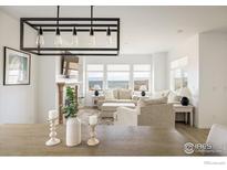 Beautiful living room with lake view, fireplace, and modern lighting at 16568 W 92Nd Pl, Arvada, CO 80007