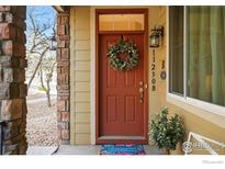 Charming front door with a welcoming wreath and address displayed vertically at 11230 Osage Cir # B, Northglenn, CO 80234