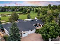 Stunning aerial view of home with mature trees, golf course, and picturesque pond at 7155 Rustic Trl, Boulder, CO 80301