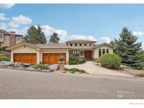 Inviting single-Gathering home featuring a three-car garage and a beautifully landscaped front yard on a sunny day at 10113 Thunder Run, Littleton, CO 80125