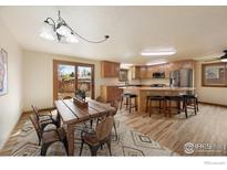 Bright kitchen boasts wood cabinets, stainless steel appliances, and a large island with bar seating at 1410 Oak Dr, Berthoud, CO 80513