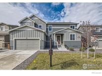 Charming two-story home with a well-manicured lawn and attached two-car garage in a suburban neighborhood at 38 Morgan S Cir, Erie, CO 80516