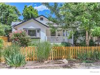 Charming two-story home featuring a cozy porch and a well-manicured front yard with a decorative wooden fence at 721 Concord Ave, Boulder, CO 80304