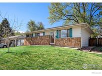 Charming single-story home featuring a stone facade and a well-maintained lawn at 2 Lincoln Pl, Longmont, CO 80501