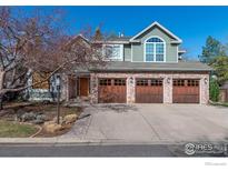 Charming home featuring brick accents, a well-manicured lawn, and a spacious three-car garage at 2345 Spotswood Pl, Boulder, CO 80304