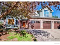 Charming two-story home boasts a three-car garage and inviting brick facade with beautiful landscaping at 2345 Spotswood Pl, Boulder, CO 80304