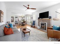 Bright living room with fireplace, ceiling fan, and open floorplan to dining area at 1282 S Sherman St, Denver, CO 80210